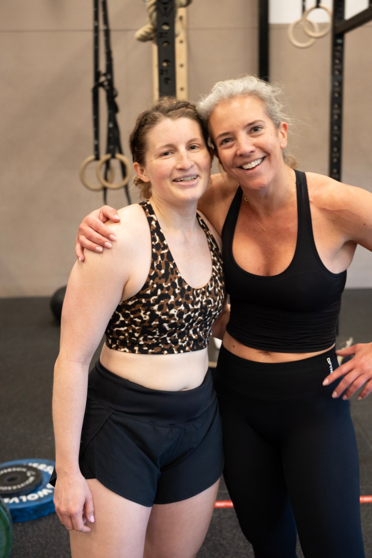 Two members smiling, arms around each other
