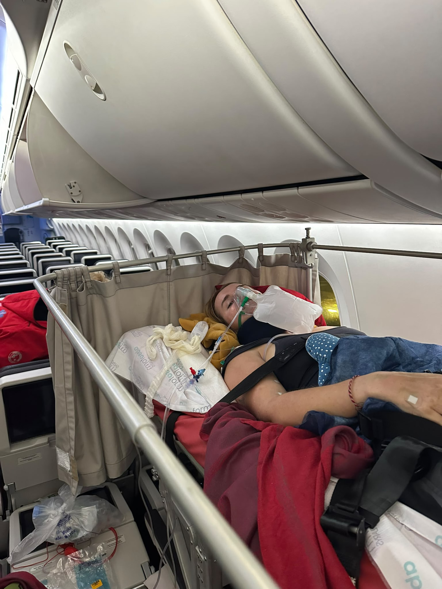 Georgia lying on a stretcher inside the aircraft