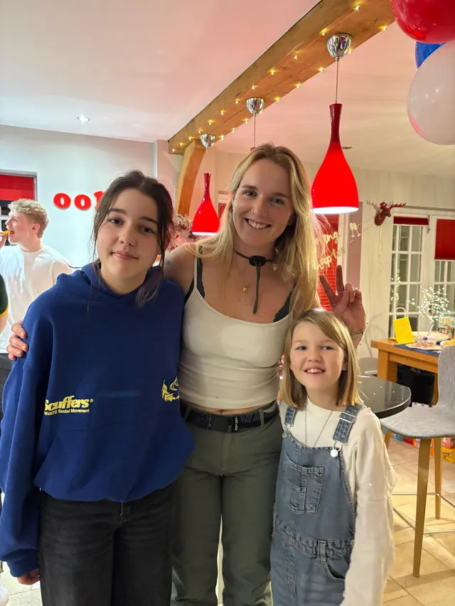 Georgia smiling indoors with two others