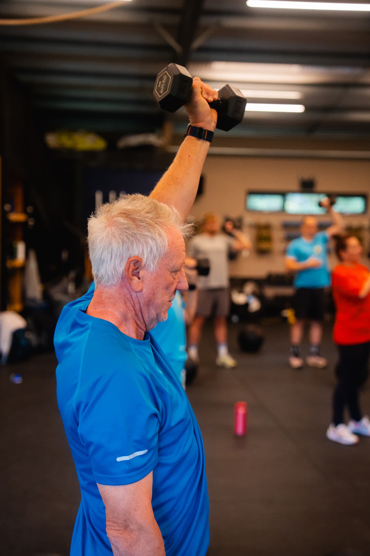 An EverStrong member pressing a dumbbell overhead