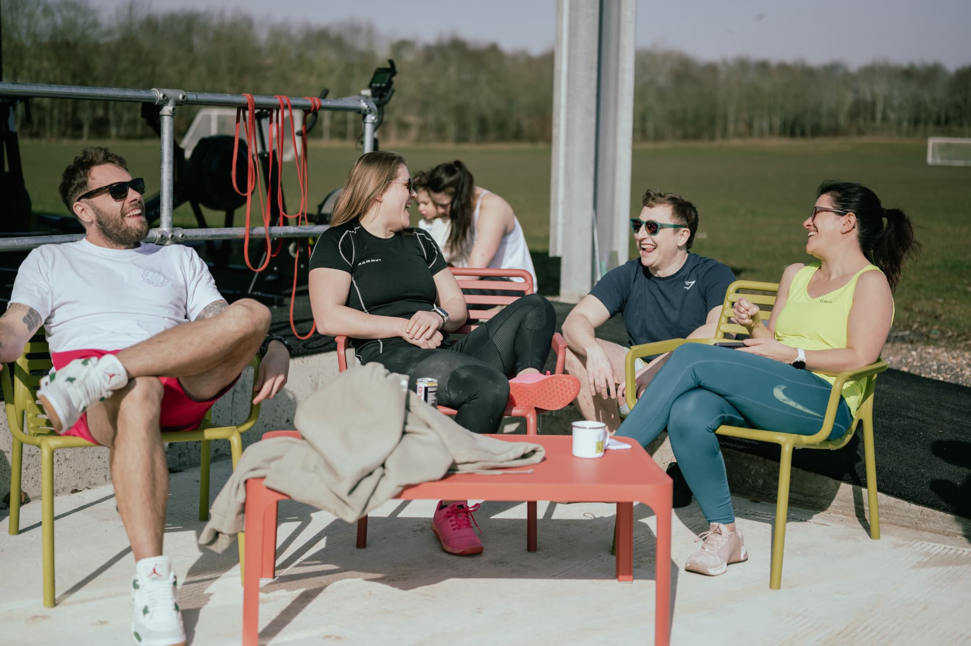 Members relaxing and chatting over coffee outside after a session