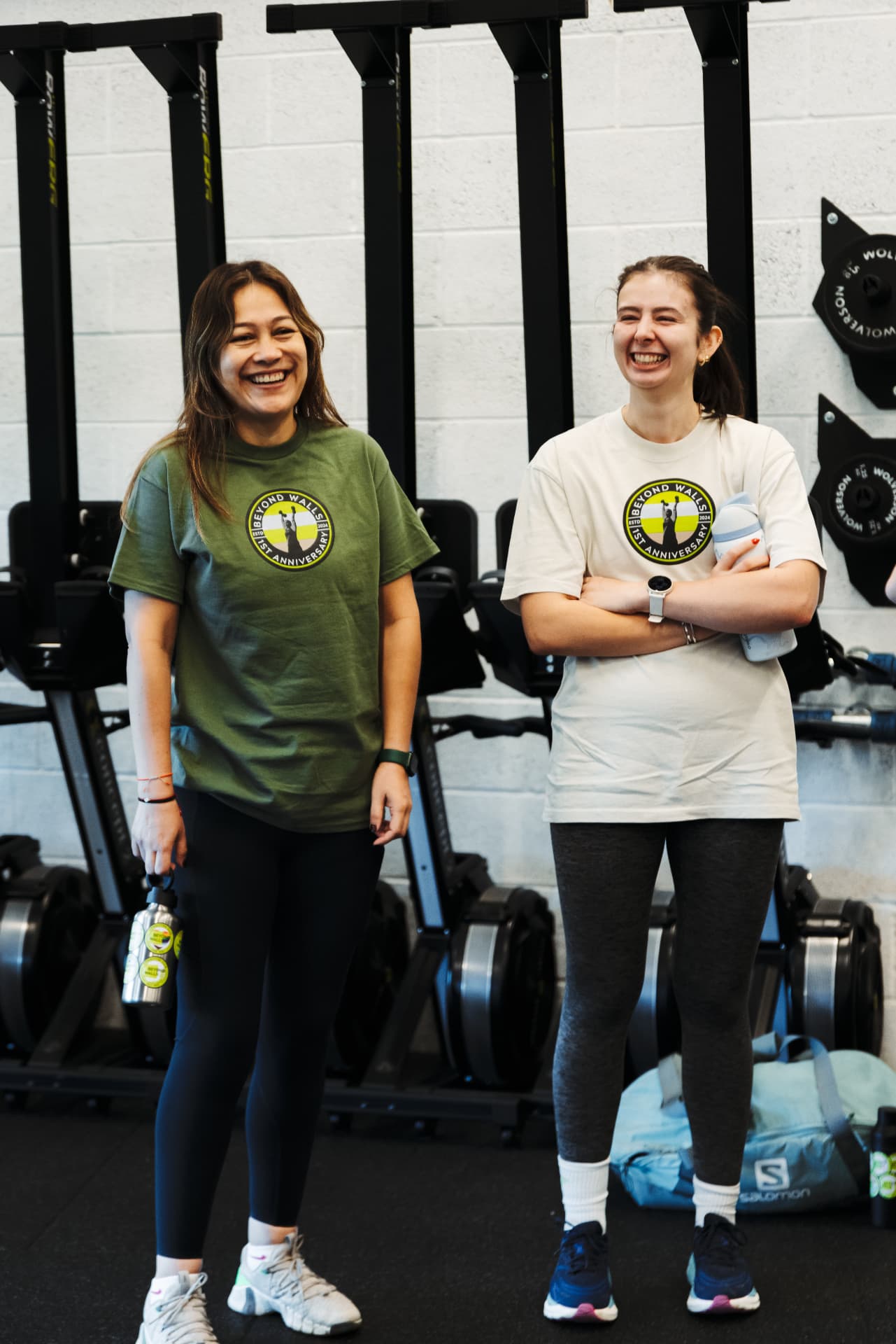 Two coaches laughing together in the gym