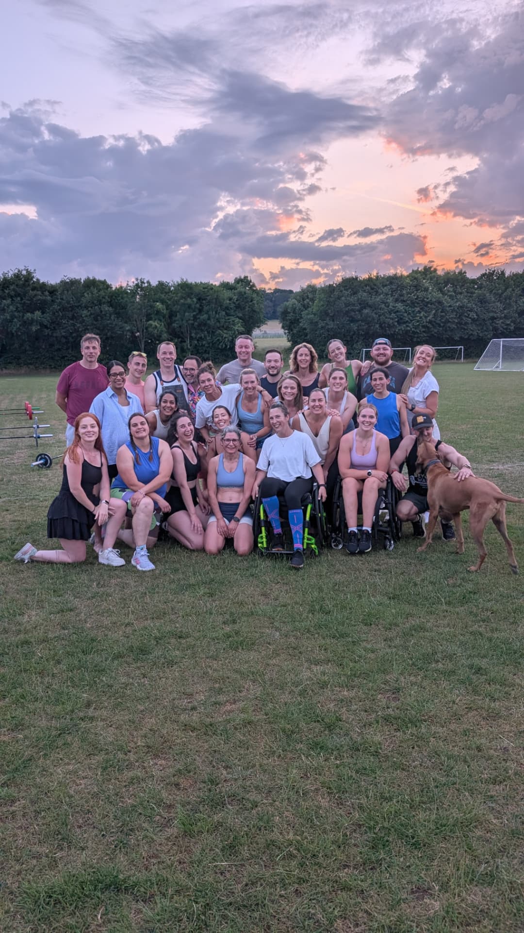 The Beyond Walls community gathered together on a grass field at sunset