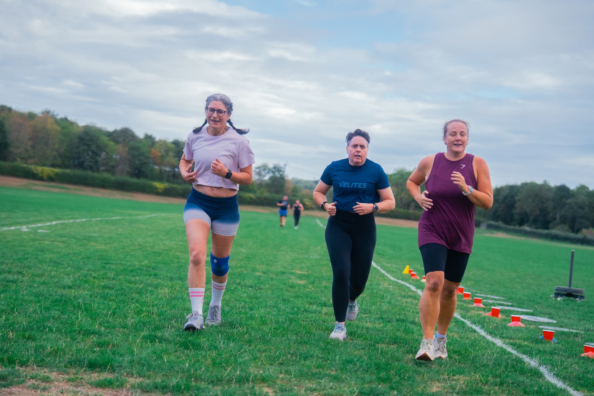 Three Beyond Walls members running side by side on the field